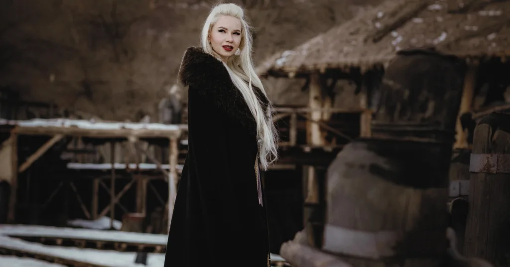 Viking women in fur coat standing in the middle of Nordic village