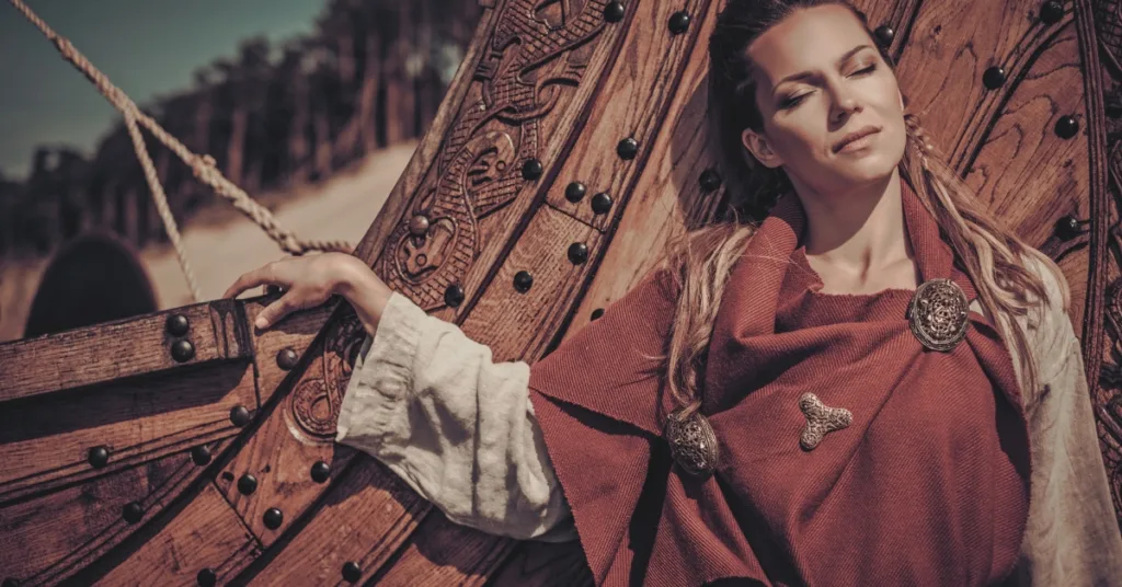 Viking woman standing in front of longship 